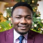 Elegant close-up portrait of a smiling man in a suit with a festive background.